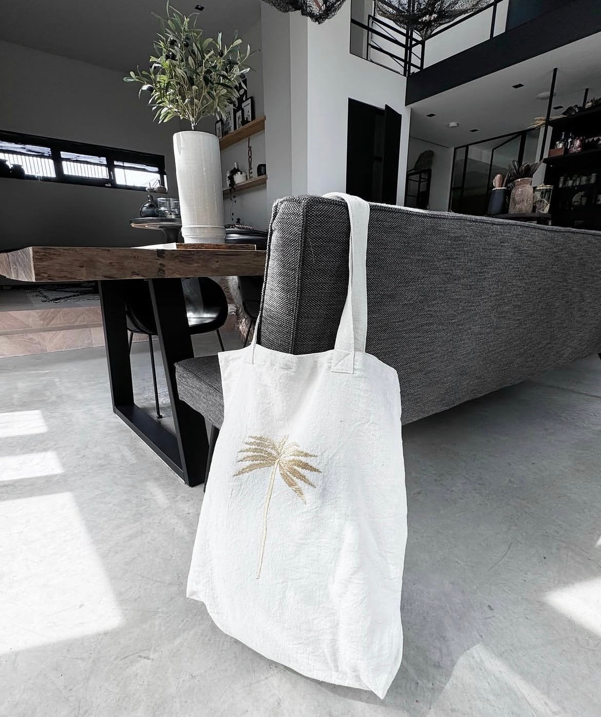 White handmade tote bag with gold palm tree embroidery in modern interior — Souhaib Creative Service Morocco