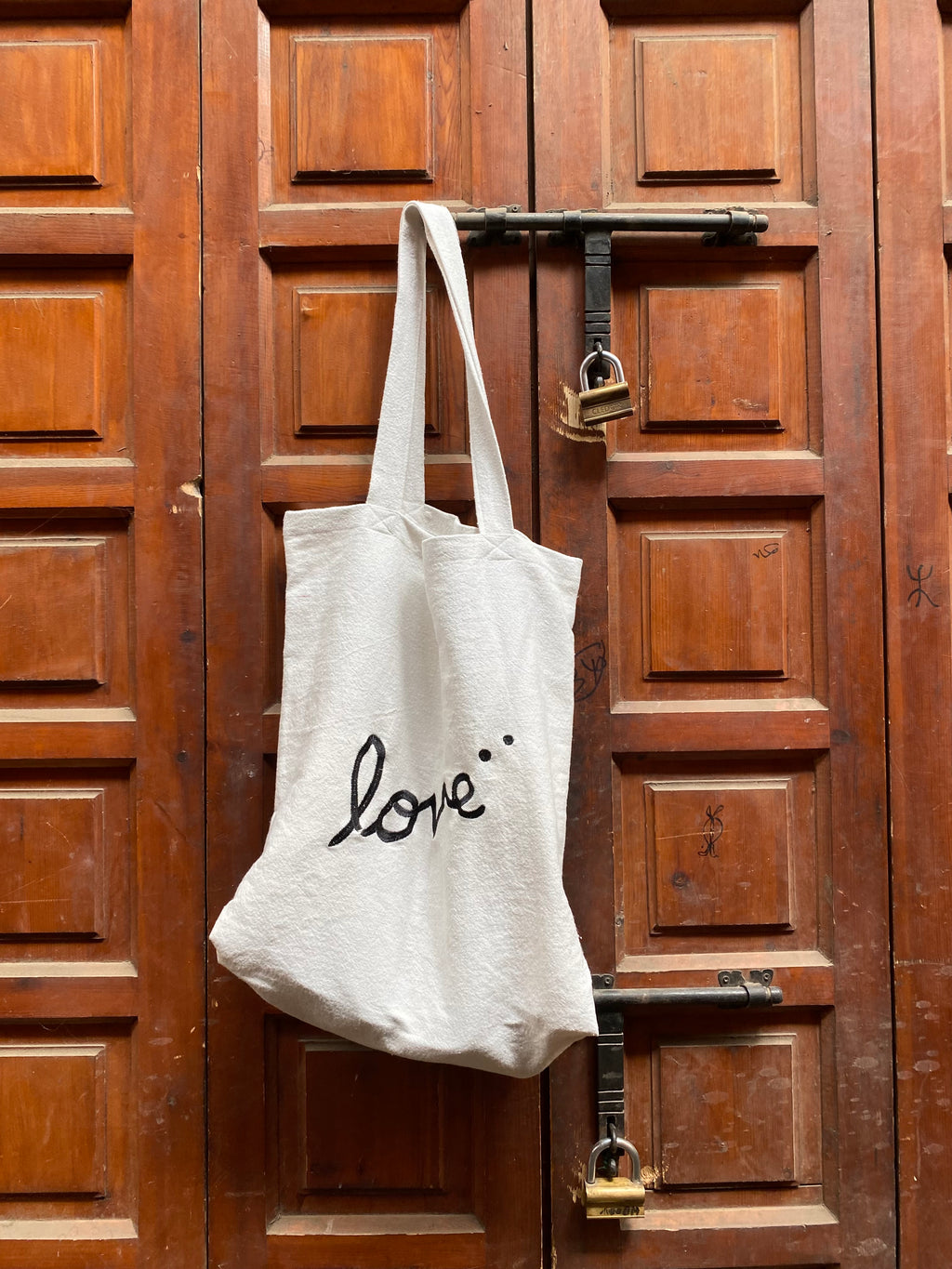 Handmade love tote bag on Moroccan medina door — unique handmade bag Morocco