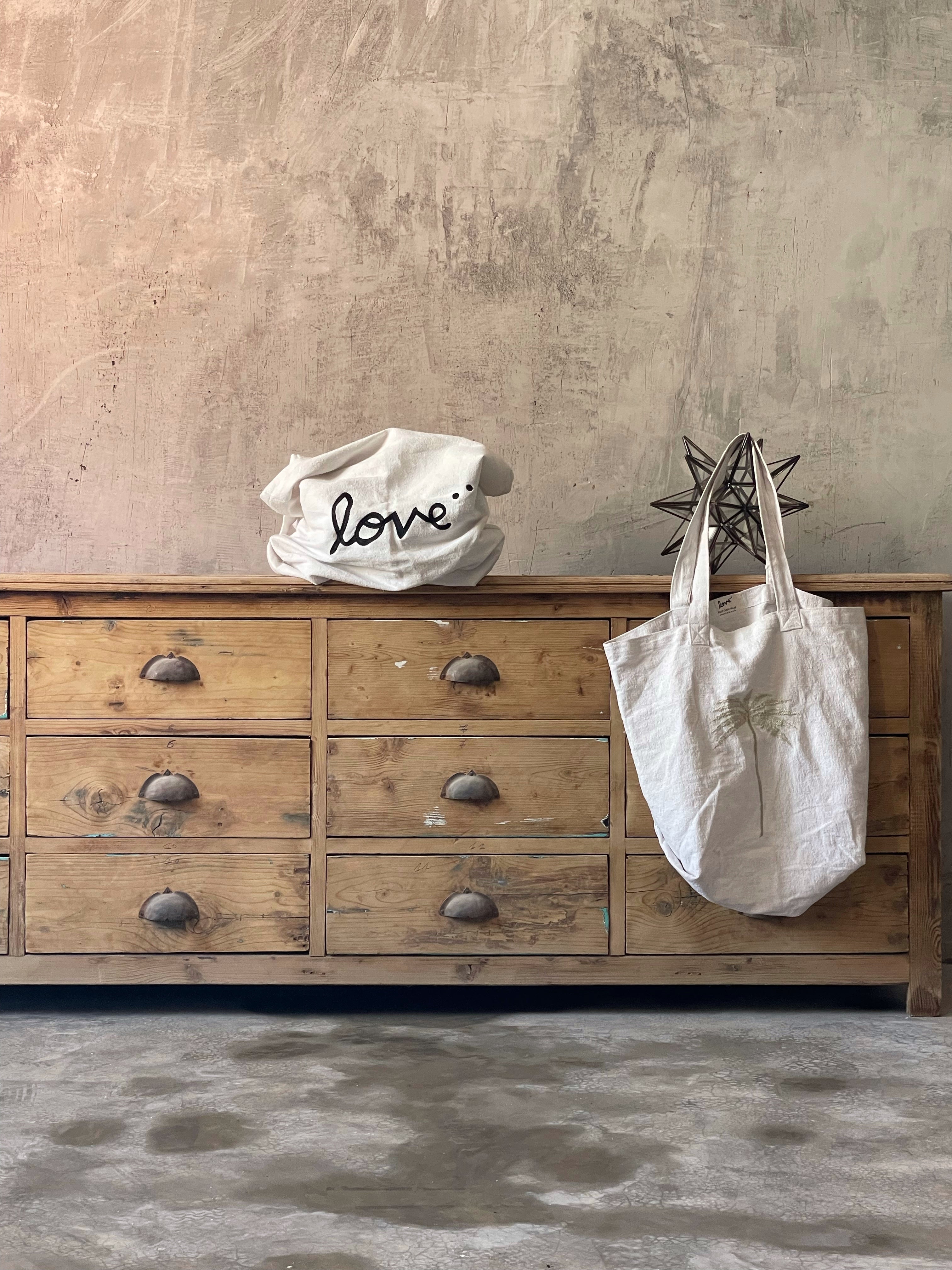 Handmade white love tote bags styled on vintage wooden dresser — Made in Morocco